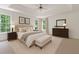 Serene main bedroom with a tray ceiling, two windows, a dresser, and carpeted floors at 84 Conner Glenn Dr, Hiram, GA 30141