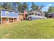 Backyard view of a blue home with a deck, lawn, and mature trees at 1646 Highway 92 N, Fayetteville, GA 30214
