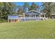 Backyard view of a blue house featuring a large deck and sloping lawn at 1646 Highway 92 N, Fayetteville, GA 30214