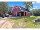 This is a unique two story red barn with a car port and tractor outside at 1646 Highway 92 N, Fayetteville, GA 30214