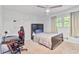 Bright bedroom with a cozy bed, a ceiling fan, a desk, and a window with bright natural light at 1646 Highway 92 N, Fayetteville, GA 30214