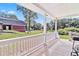 A lovely porch with white railing overlooks a spacious green lawn surrounded by trees at 1646 Highway 92 N, Fayetteville, GA 30214