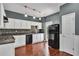 Kitchen featuring white cabinets, black appliances and hardwood floors at 7120 Oakley Ct, Union City, GA 30291