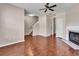 Well-lit living room with hardwood floors, a fireplace, ceiling fan, and staircase at 7120 Oakley Ct, Union City, GA 30291