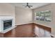 Open living space with a fireplace, ceiling fan, and large window providing abundant natural light at 7120 Oakley Ct, Union City, GA 30291