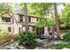 A two-story home with mature trees, a patio with dining, and a pathway leading through lush greenery at 138 Garland Ave, Decatur, GA 30030