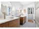 Elegant bathroom with dual sinks, wood cabinets, decorative mirrors, and access to a walk-in closet at 138 Garland Ave, Decatur, GA 30030
