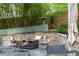 Outdoor seating area with comfortable chairs surrounding a fire pit, set on a stone patio with bamboo at 138 Garland Ave, Decatur, GA 30030