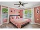 Pink bedroom featuring a ceiling fan, two windows, and hardwood floors at 1932 Brenda Dr, Austell, GA 30168