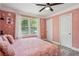 Pink bedroom featuring a ceiling fan, one window, and hardwood floors at 1932 Brenda Dr, Austell, GA 30168