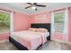 Bright bedroom featuring a ceiling fan, two windows, and hardwood floors at 1932 Brenda Dr, Austell, GA 30168