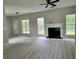 Bright living room with a fireplace, modern gray flooring, and large windows at 2711 Teal Landing Dr, Morrow, GA 30260