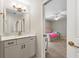 Bathroom vanity featuring white cabinets, stone countertop, and gold hardware, leading into bedroom at 5652 Harbormist Dr, Powder Springs, GA 30127