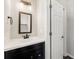 Bathroom features a modern vanity with dark wood cabinets and a framed mirror, alongside a white door at 5652 Harbormist Dr, Powder Springs, GA 30127