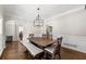 Elegant dining area with hardwood floors, wainscoting, and a modern chandelier at 5652 Harbormist Dr, Powder Springs, GA 30127