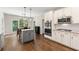 Open kitchen with white cabinetry, stainless steel appliances, and a cozy breakfast nook at 5652 Harbormist Dr, Powder Springs, GA 30127