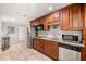 This kitchenette features brown cabinets, stainless steel appliances and tile flooring at 5652 Harbormist Dr, Powder Springs, GA 30127