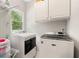Well-lit laundry room equipped with modern washer and dryer units and ample storage at 5652 Harbormist Dr, Powder Springs, GA 30127