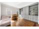 Living room featuring hardwood floors and built-in cabinets and shelving, with natural light from multiple windows at 5652 Harbormist Dr, Powder Springs, GA 30127