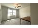 Bedroom with light-filled window, ceiling fan, plush carpeting, and a wooden table at 1835 Wellston Dr, Lawrenceville, GA 30043