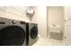 Laundry room with modern washer and dryer, utility sink, and wire shelving at 1835 Wellston Dr, Lawrenceville, GA 30043