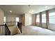Open loft space with plush carpeting, natural light from windows, and staircase with black railings at 1835 Wellston Dr, Lawrenceville, GA 30043