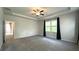Large primary bedroom featuring tray ceilings, neutral paint and carpet, and plenty of natural light at 1835 Wellston Dr, Lawrenceville, GA 30043