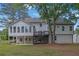 Expansive backyard with mature trees and lush green grass. Large back of house with deck and stairs at 2506 Octavia Ln, Marietta, GA 30062