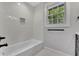 Chic bathroom featuring tiled walls, a bathtub, and a vanity with modern black hardware at 2506 Octavia Ln, Marietta, GA 30062