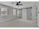 Spacious bedroom with grey walls, carpet, a ceiling fan, and sliding barn doors to a closet at 2506 Octavia Ln, Marietta, GA 30062