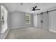 Large bedroom featuring grey walls, carpet, a ceiling fan, and sliding barn doors to a closet at 2506 Octavia Ln, Marietta, GA 30062