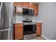 This kitchen features stainless steel appliances, including an oven, a microwave and dark wood cabinets at 325 Berry Ct, Villa Rica, GA 30180