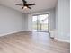 Living room with wood-look flooring, a ceiling fan, a sliding glass door to a balcony, and a window at 325 Berry Ct, Villa Rica, GA 30180