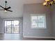 Bright living room with a ceiling fan, a hanging chandelier, sliding glass doors to a balcony, and a window at 325 Berry Ct, Villa Rica, GA 30180