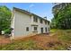 Backyard view of a two-story home with a spacious yard and patio at 4325 Camellia Ridge Sw Way, Lilburn, GA 30047