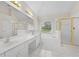 Bright bathroom with double sinks, shower, and tub beneath a sunny window at 4325 Camellia Ridge Sw Way, Lilburn, GA 30047