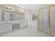 Bright primary bathroom with white cabinets, double sinks, shower, and tub beneath a sunny window at 4325 Camellia Ridge Sw Way, Lilburn, GA 30047