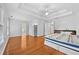 Spacious main bedroom features a tray ceiling, a ceiling fan, and light hardwood floors at 4325 Camellia Ridge Sw Way, Lilburn, GA 30047