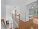 Upstairs hallway with wood floors, open staircase, bedroom view and natural light at 4325 Camellia Ridge Sw Way, Lilburn, GA 30047