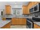 Bright kitchen features granite countertops, stainless steel appliances, light wood cabinets, tile backsplash and window view at 4325 Camellia Ridge Sw Way, Lilburn, GA 30047