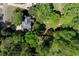 A drone captures the house nestled among mature trees, with a peek at the side yard and driveway at 4915 Bayberry Dr, Cumming, GA 30040