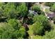 This aerial shot captures the house surrounded by mature trees, a green lawn, and a partial view of the street at 4915 Bayberry Dr, Cumming, GA 30040