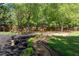 Spacious backyard featuring mature trees, lush lawn, and a stone bird bath, creating a serene outdoor oasis at 4915 Bayberry Dr, Cumming, GA 30040