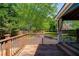 Outdoor deck area with wood railings and floor, overlooking the landscaped backyard with mature trees at 4915 Bayberry Dr, Cumming, GA 30040