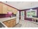 Traditional kitchen with wood cabinets, tile floors, purple accent wall, and door to the backyard at 4915 Bayberry Dr, Cumming, GA 30040