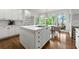 Bright kitchen features a center island with cooktop and eat-in dining area with views of the trees at 5065 Harbour Ridge Dr, Alpharetta, GA 30005