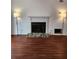 Living room with a fireplace, flanked by lamps, and dark wood floors at 1502 Countryside Se Pl # 1502, Smyrna, GA 30080