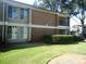 A brick apartment building with large windows and well-maintained landscaping with a lawn at 3301 Henderson Mill Rd # J1, Atlanta, GA 30341