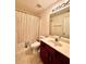 Well-lit bathroom with a vanity, toilet, shower-tub combo and neutral-toned finishes at 3981 Isaac Ct, Lilburn, GA 30047