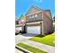 Two-story brick home boasting a two-car garage, manicured lawn, and classic design at 3981 Isaac Ct, Lilburn, GA 30047